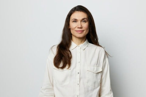Portrait Of A Beautiful Happy Attractive Adult Woman In A White Shirt On A White Background