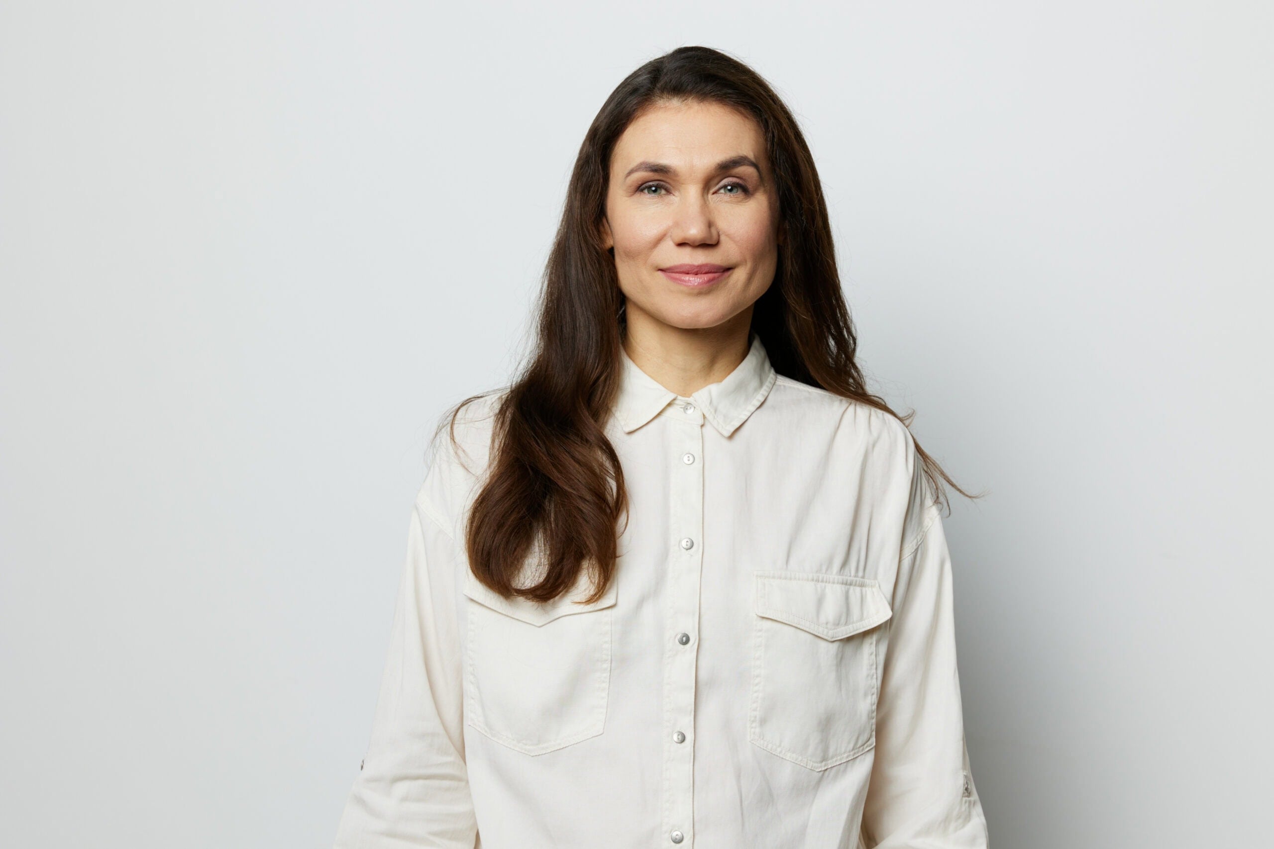 Portrait Of A Beautiful Happy Attractive Adult Woman In A White Shirt On A White Background