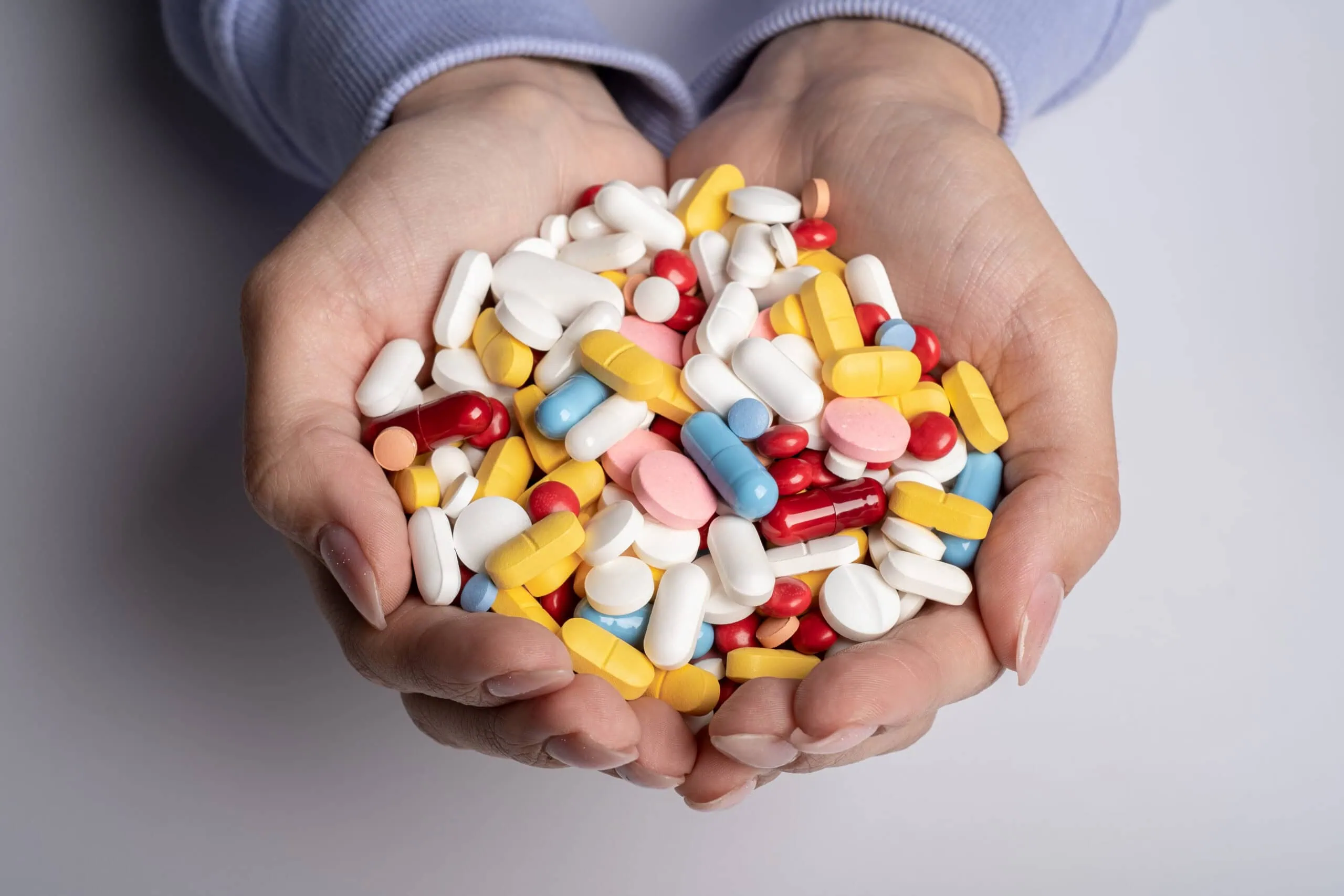 Woman Hands Full Of Various Pills. Healthcare Or Medical Concept.