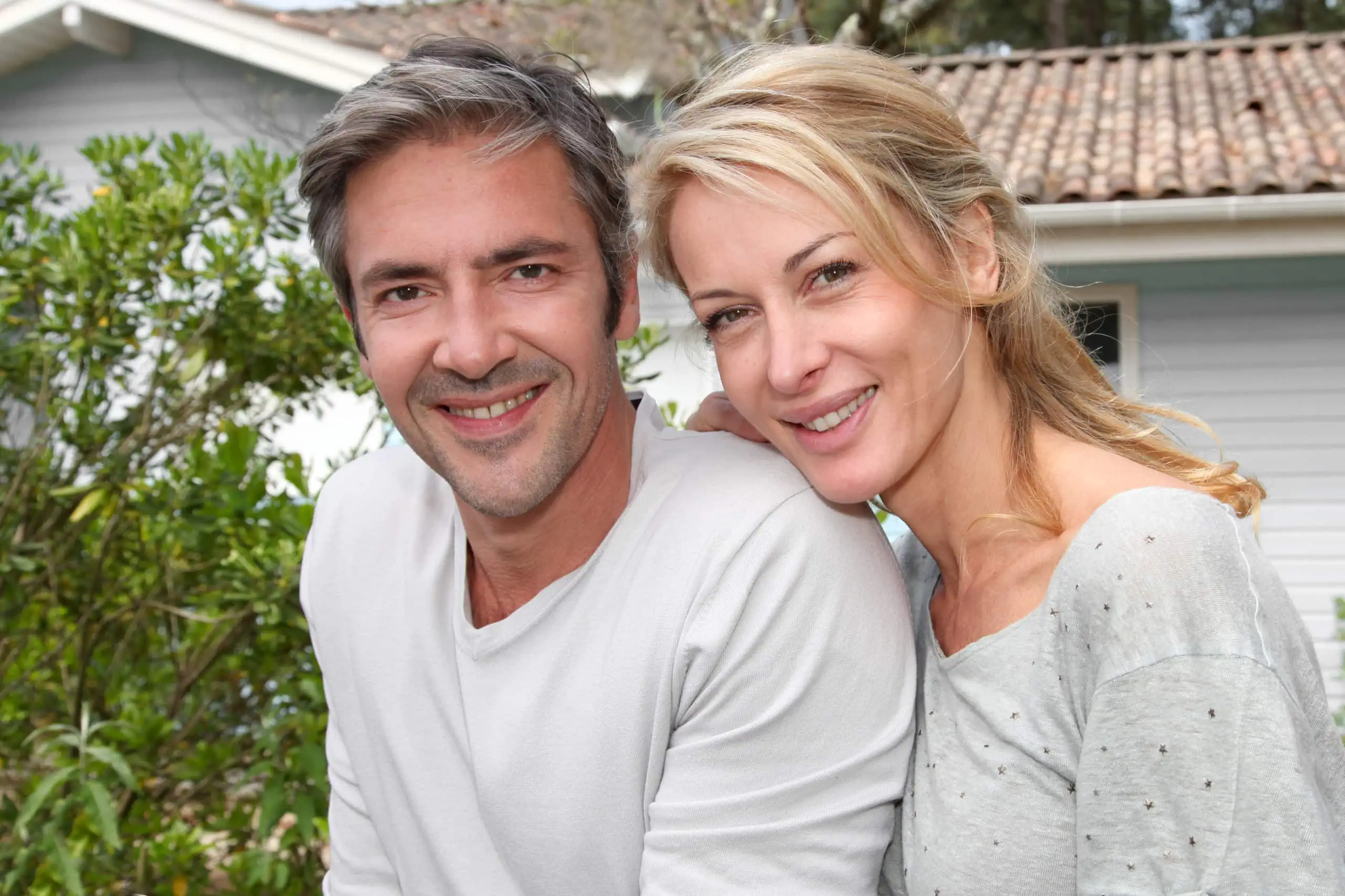 Happy,couple,sitting,in,from,of,their,new,home