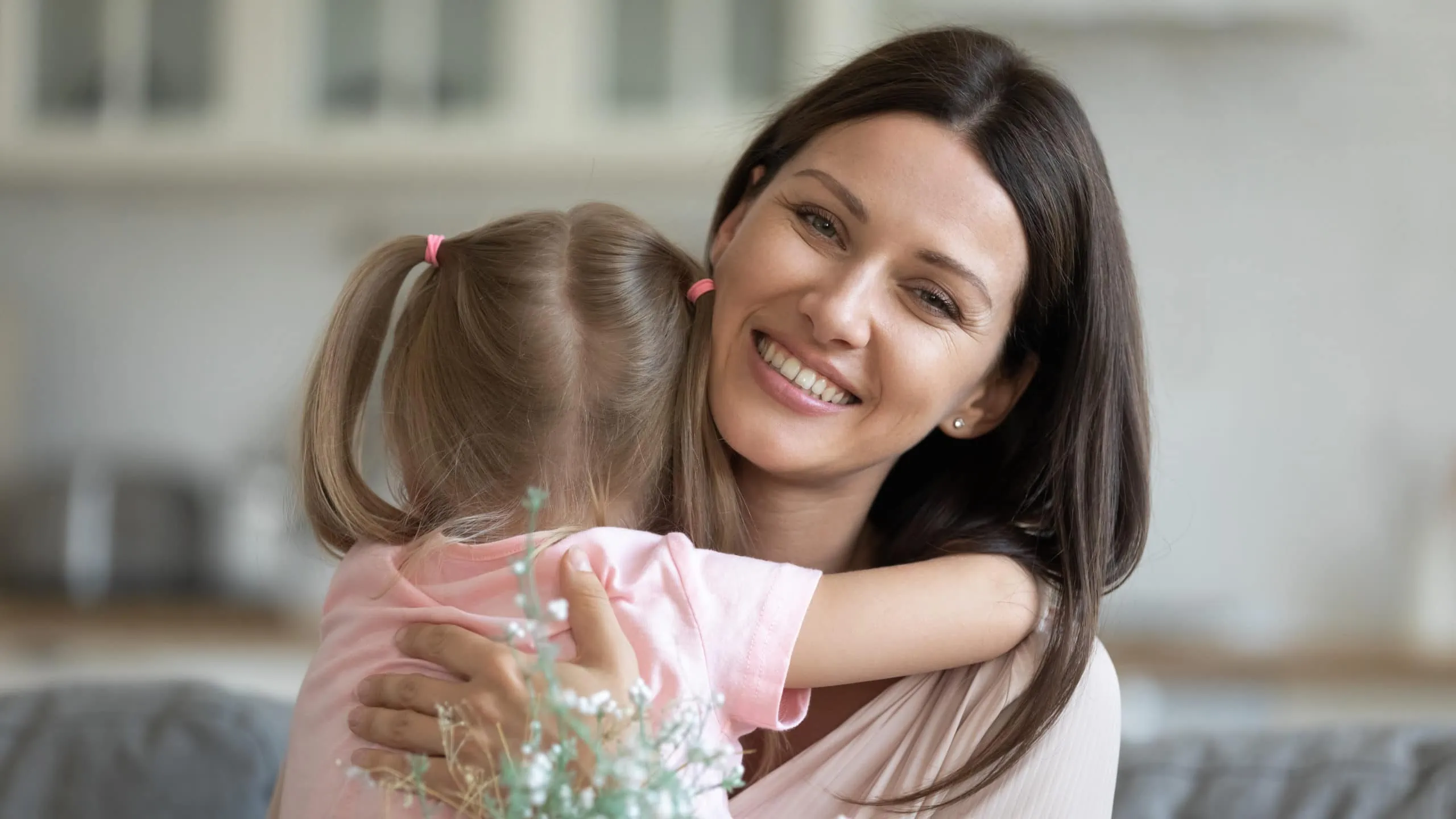 Beautiful,female,holding,white,field,pretty,flowers,hug,little,daughter
