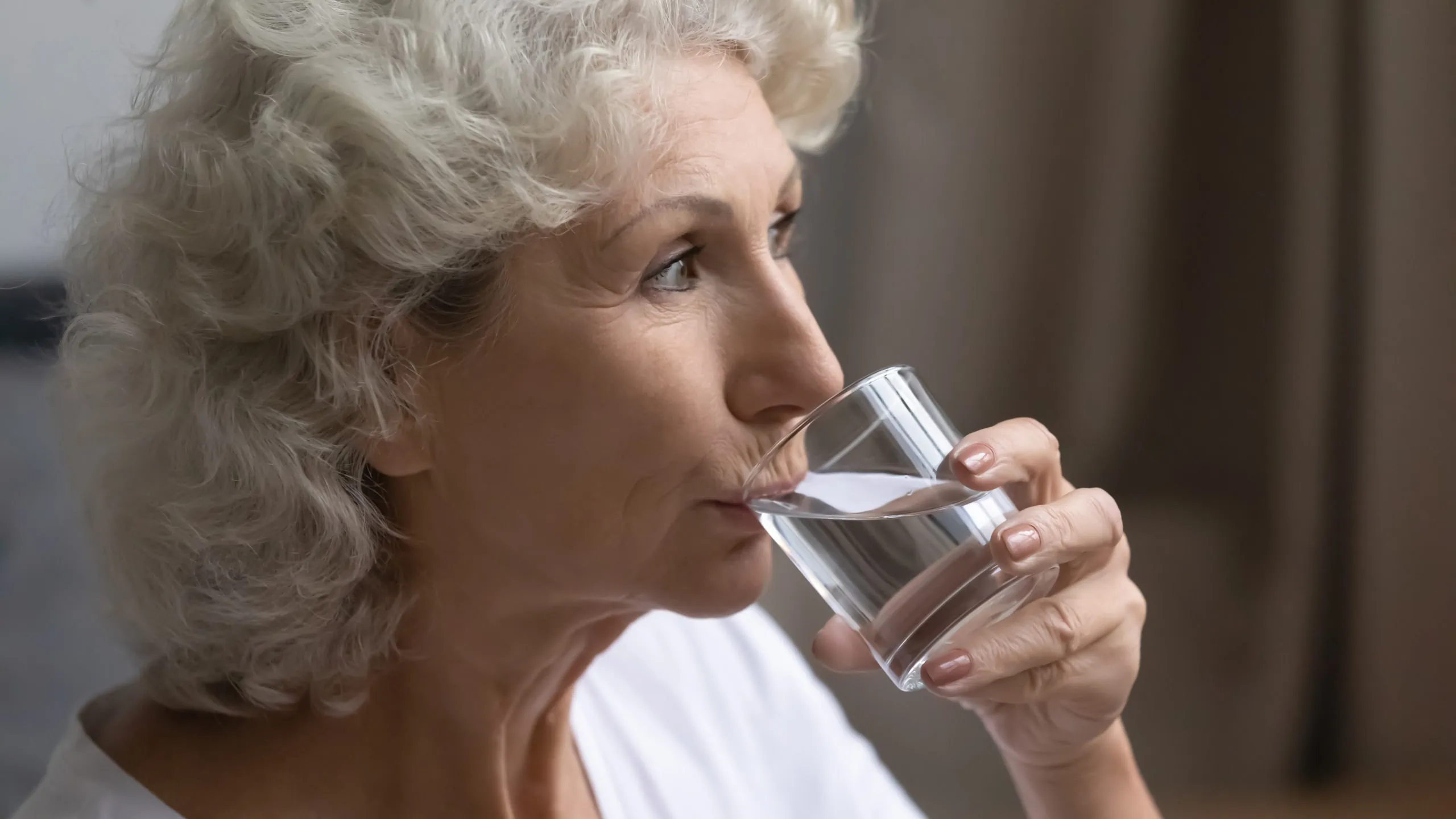 Close,up,aged,woman,hold,glass,drink,still,water,enjoy