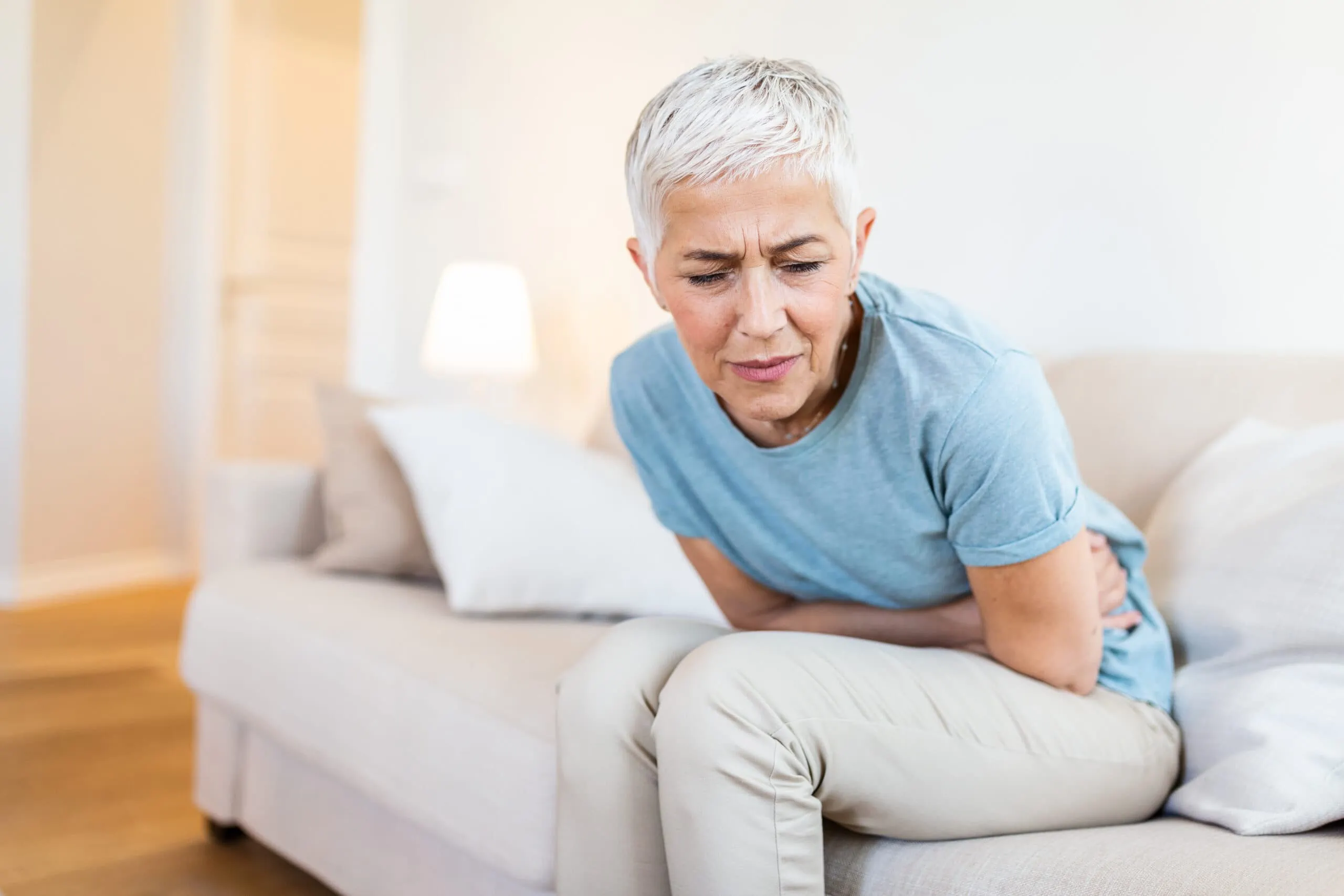 Middle Aged,woman,sitting,on,bed,feels,unhealthy,touch,stomach,suffers