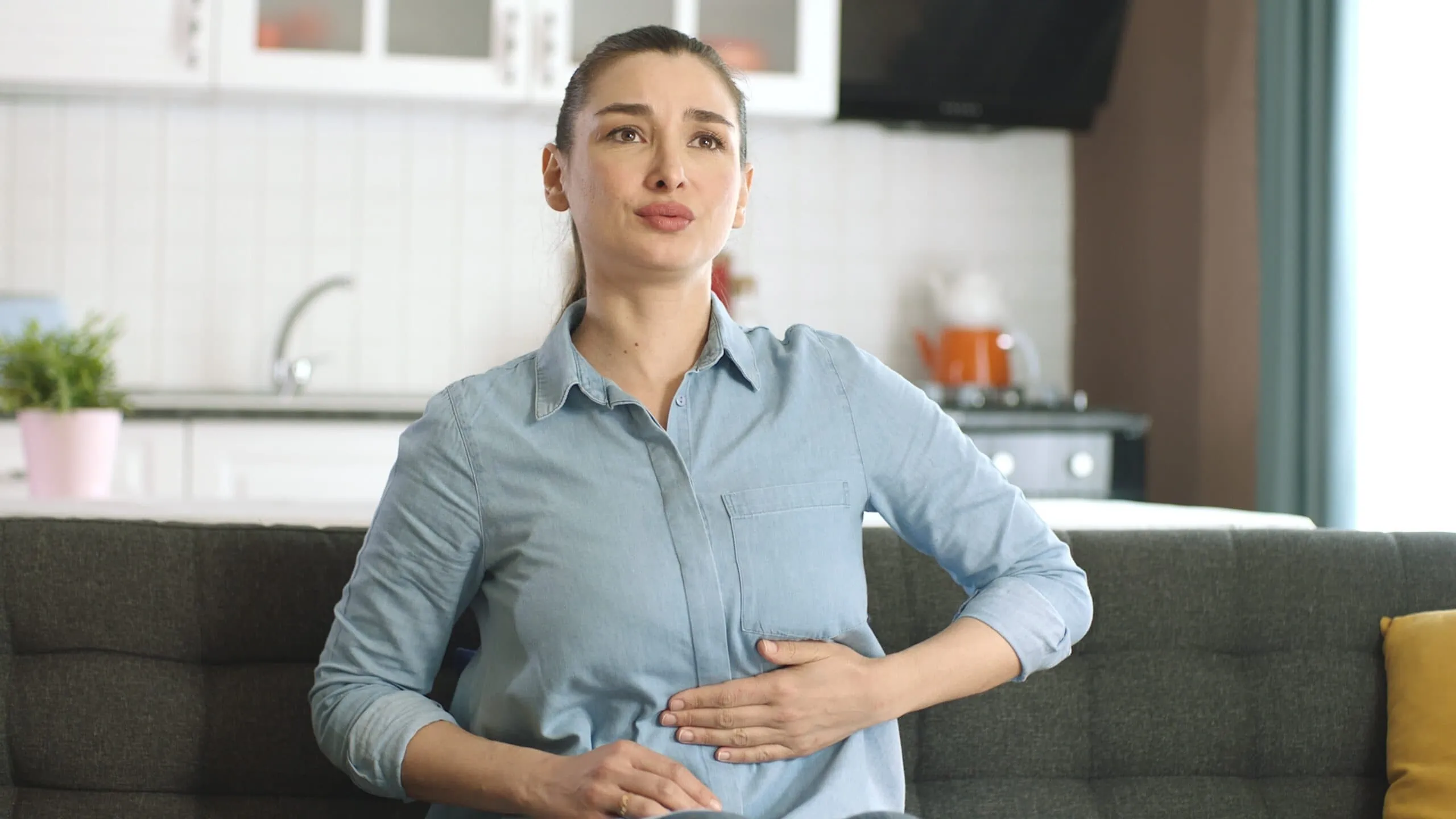 Young,woman,suffering,from,stomach,spasm,,abdominal,pain,at,home.