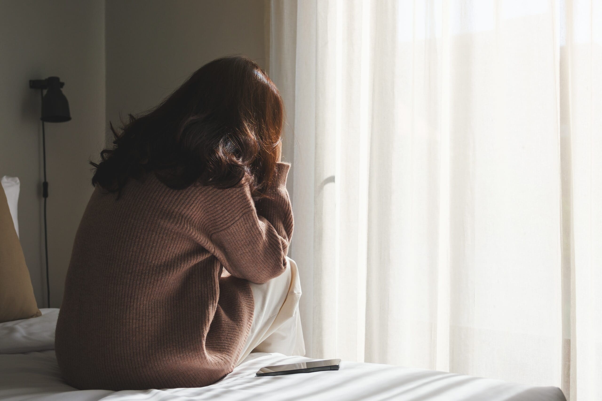 Rear,view,of,a,sad,woman,after,reading,bad,news
