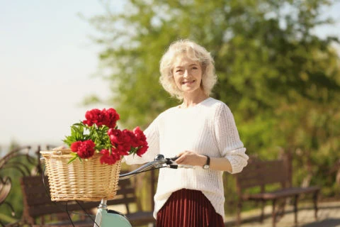 Beautiful,middle,aged,woman,with,bicycle,in,park